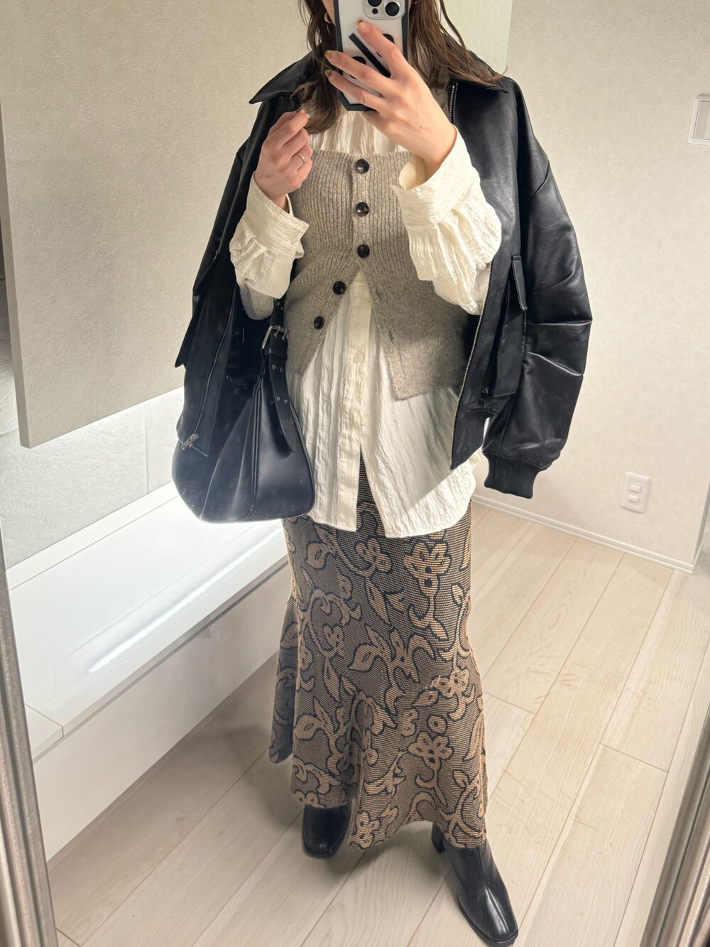 ベージュ系のベスト、ホワイト系のシャツ/ブラウス、ブラック系のスカートを着用したレディースの冬コーディネートの2枚目の写真
