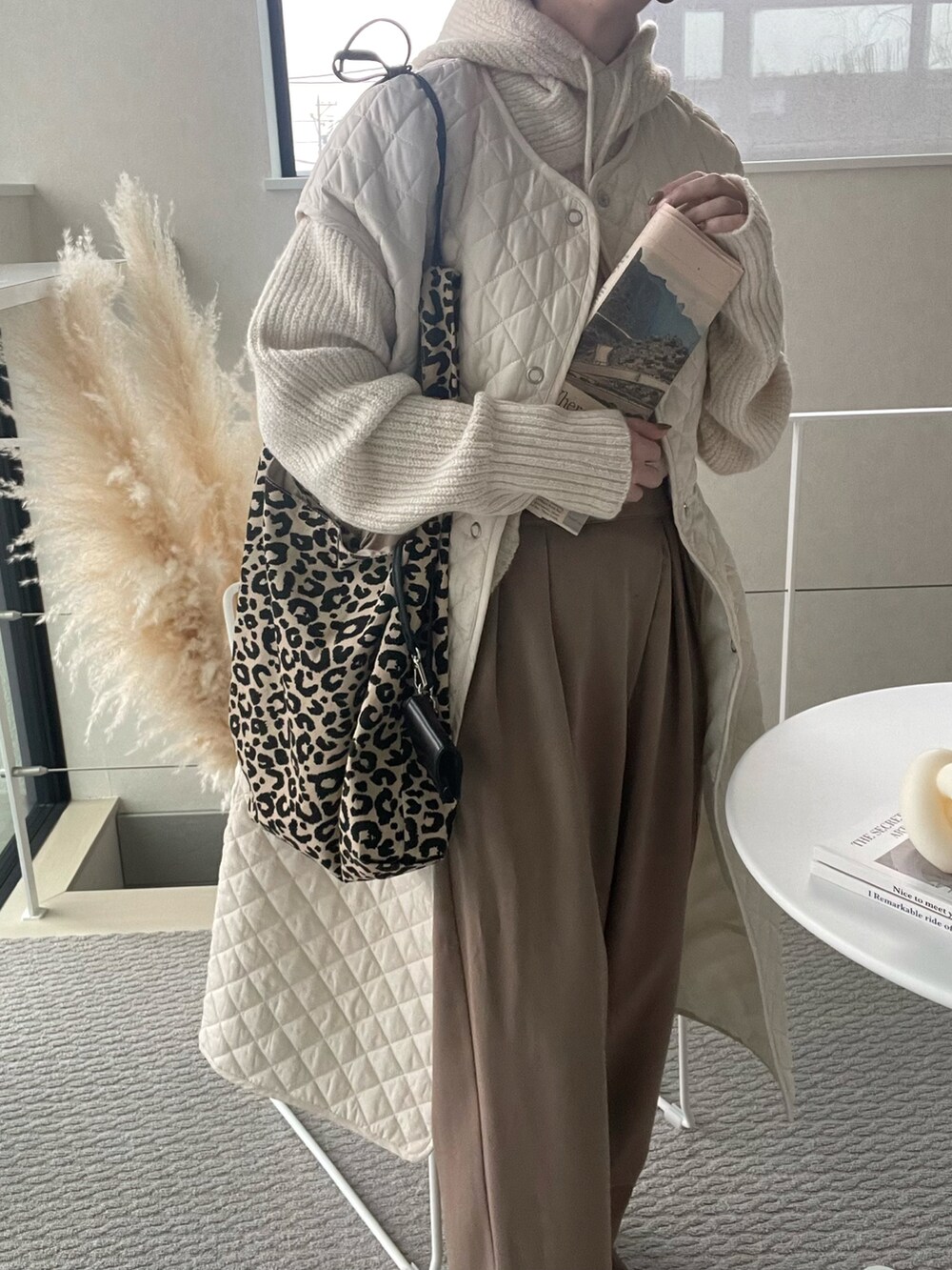 ホワイト系のその他アウター、ホワイト系のニット/セーター、ブラウン系のその他パンツを着用したレディースの冬コーディネートの2枚目の写真