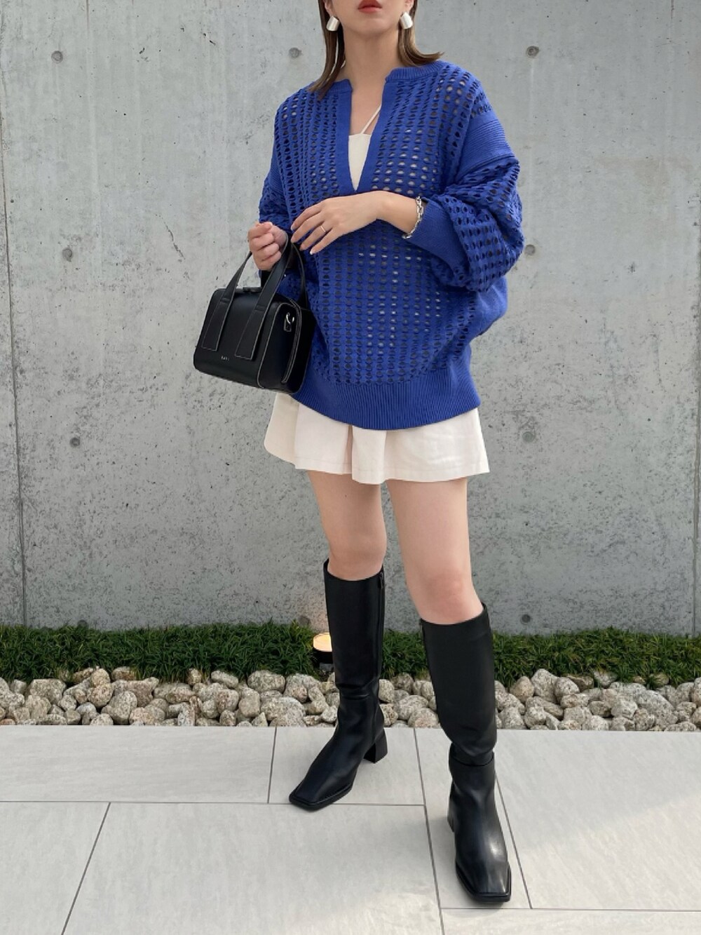 ブラック系のブーツ、ブルー系のニット/セーター、ホワイト系のその他パンツを着用したレディースの秋コーディネートの2枚目の写真