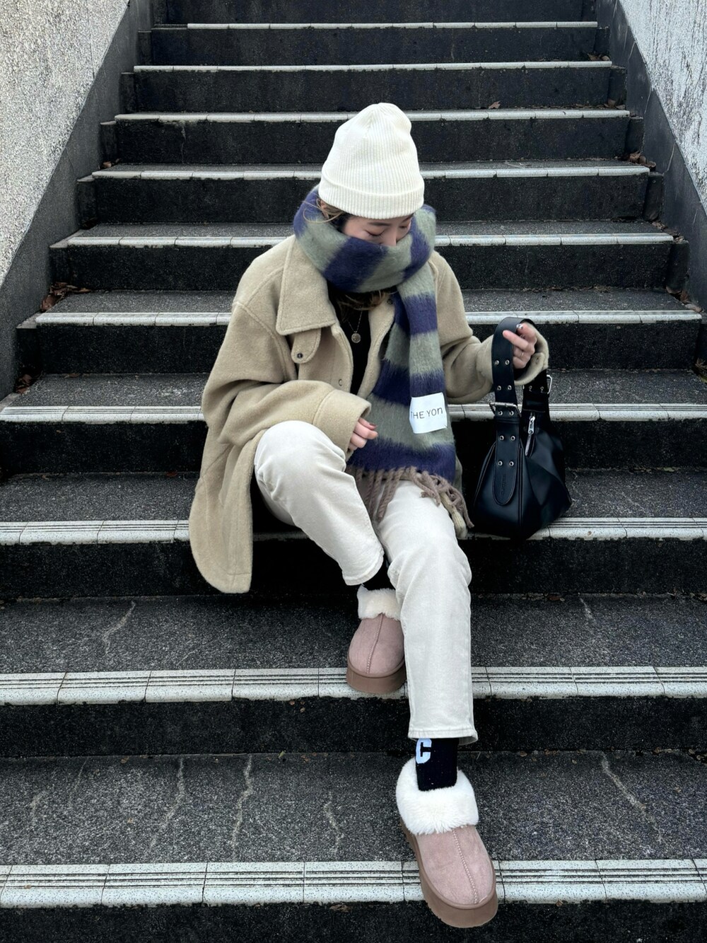 ブラック系のハンドバッグ、グリーン系のその他アウター、グリーン系のマフラーを着用したレディースの冬コーディネートの4枚目の写真