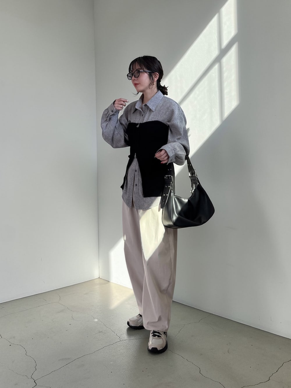 ホワイト系のチノパンツ、グレー系のシャツ/ブラウス、ブラック系のハンドバッグを着用したレディースの春コーディネートの2枚目の写真