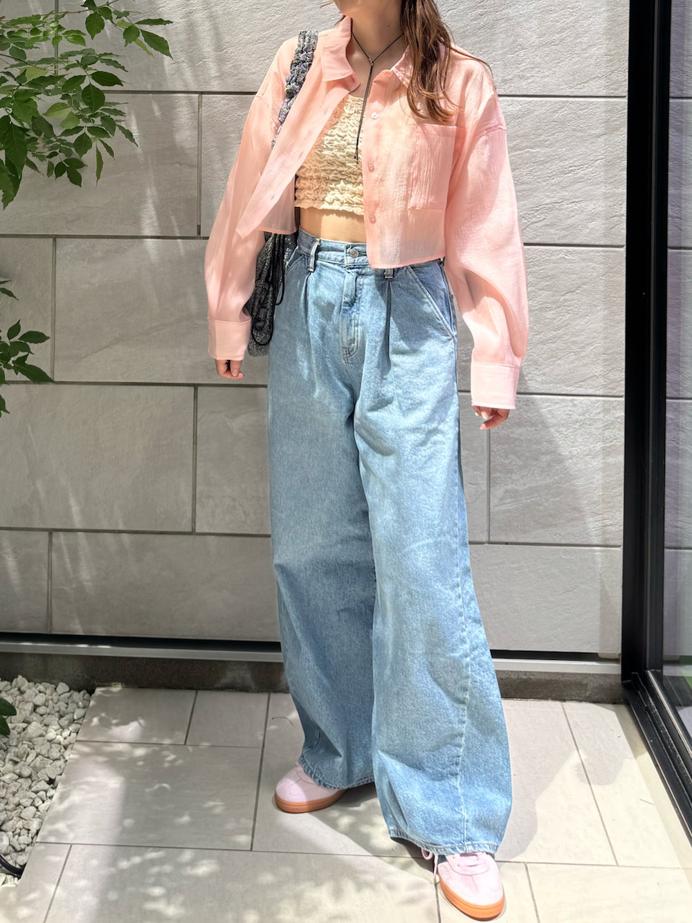 ホワイト系のタンクトップ、ブルー系のデニムパンツ、シルバー系のトートバッグを着用したレディースの夏コーディネートの4枚目の写真