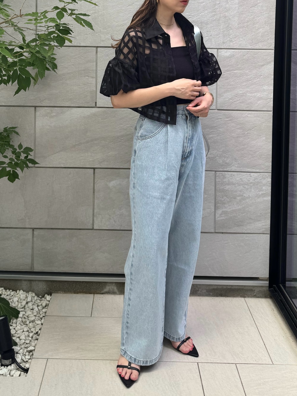 ブラック系のキャミソール、ブラック系のサンダル、ブルー系のデニムパンツを着用したレディースの夏コーディネートの4枚目の写真