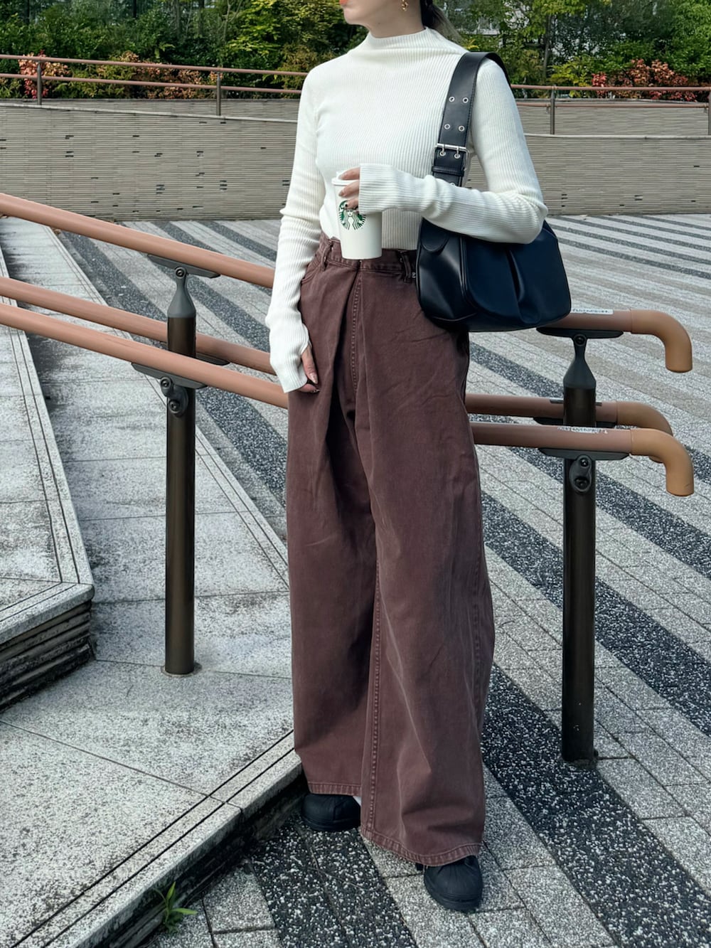 ホワイト系のニット/セーター、ブラウン系のデニムパンツ、ブラック系のスニーカーを着用したレディースの秋コーディネートの4枚目の写真