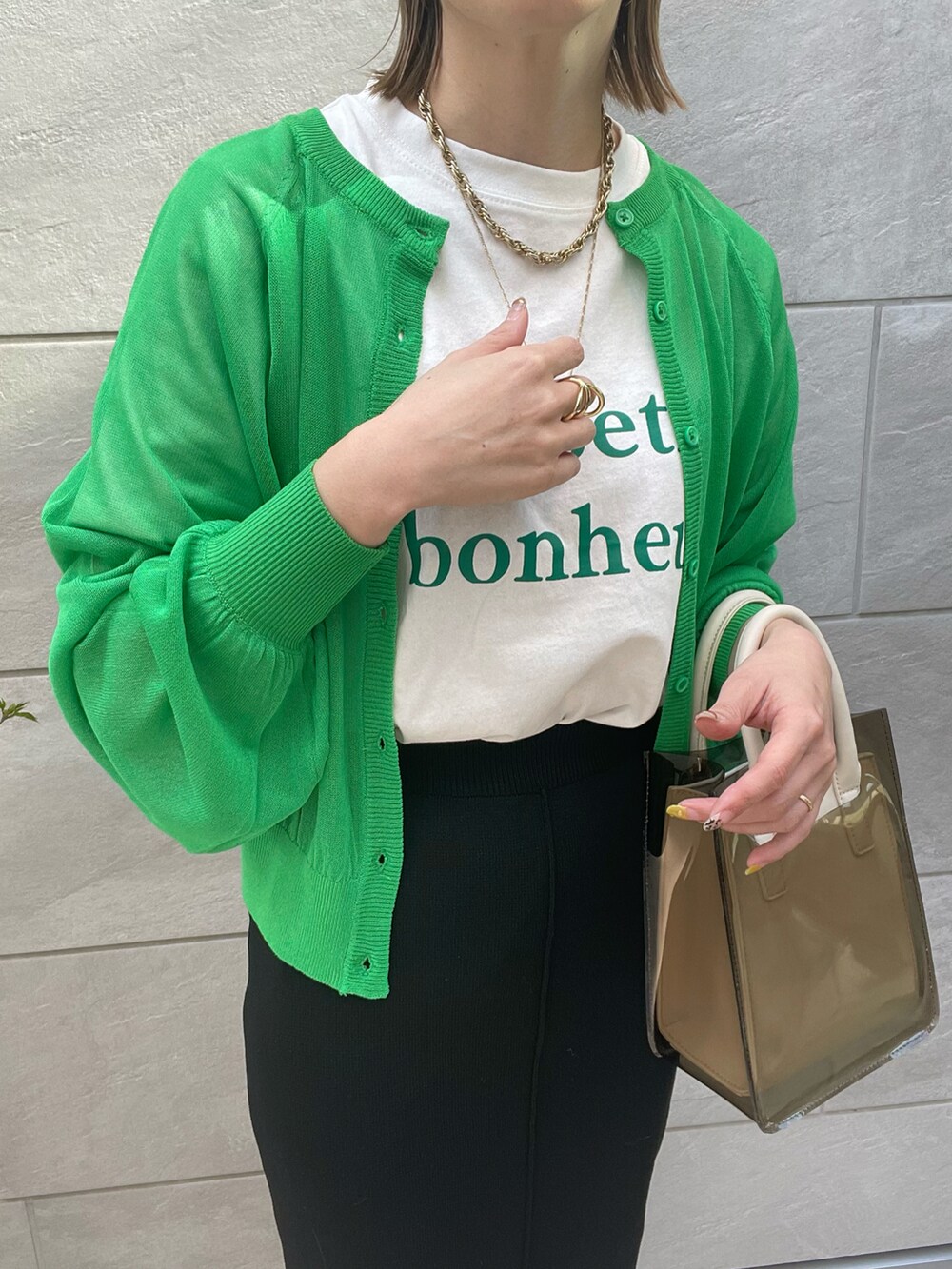 ブラック系のスカート、ホワイト系のサンダル、ホワイト系のショルダーバッグを着用したレディースの春コーディネートの3枚目の写真