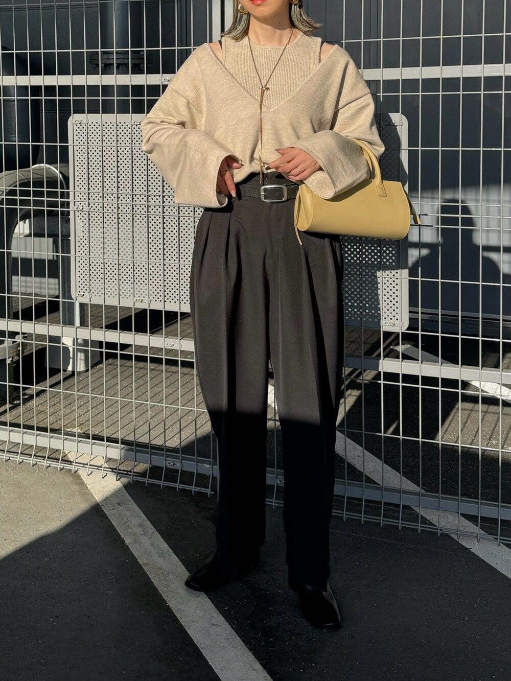 ベージュ系のニット/セーター、ブラック系のその他パンツ、ベージュ系のハンドバッグを着用したレディースの秋コーディネートの3枚目の写真