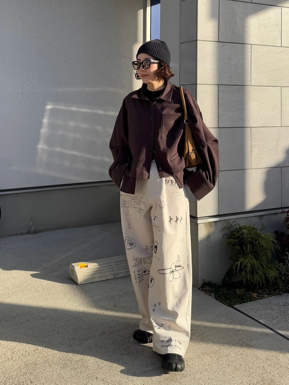 ブラウン系のシャツ/ブラウス、ホワイト系のその他パンツ、ブラック系のスニーカーを着用したレディースの冬コーディネートの2枚目の写真