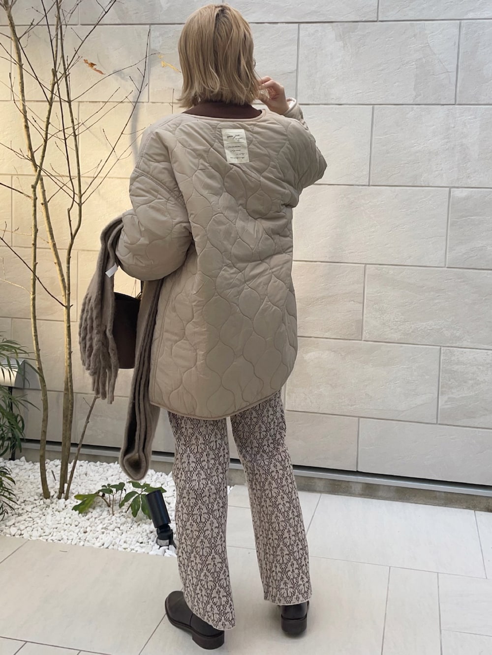 ベージュ系のブルゾン、ブラウン系のTシャツ/カットソー、ベージュ系のその他パンツを着用したレディースの秋コーディネートの3枚目の写真