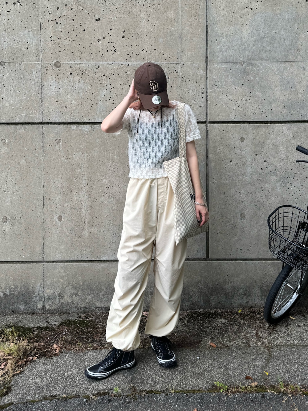 ブラック系のスニーカー、ホワイト系のTシャツ/カットソー、ベージュ系のトートバッグを着用したレディースの春コーディネートの3枚目の写真