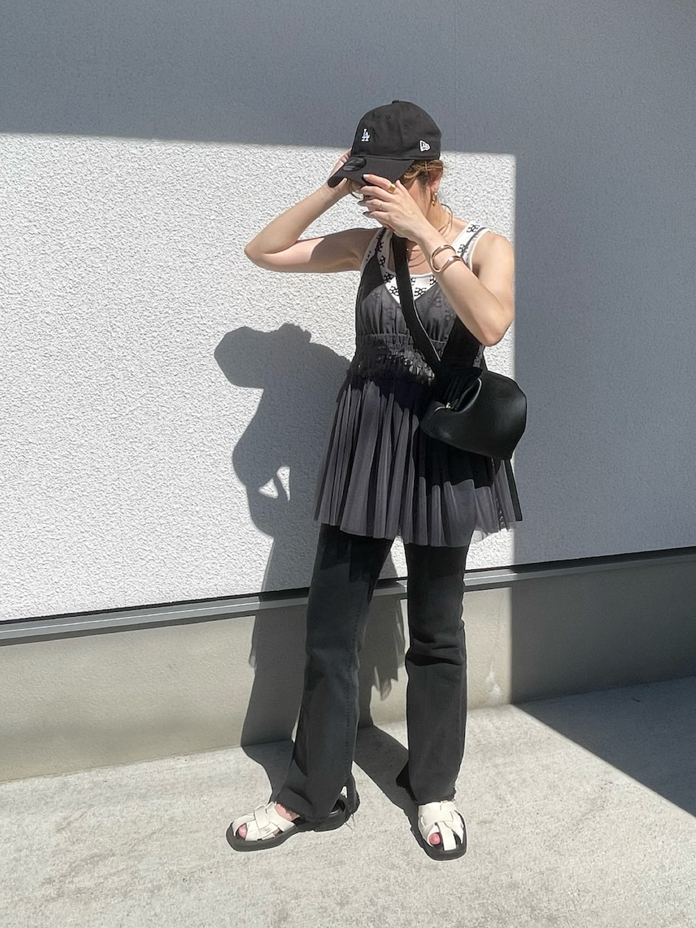 グレー系のキャミソール、ホワイト系のタンクトップ、ホワイト系のサンダルを着用したレディースの夏コーディネートの2枚目の写真