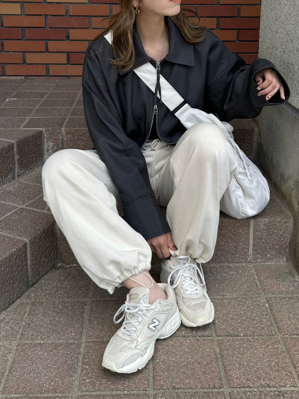 グレー系のその他アウター、ホワイト系のショルダーバッグ、グレー系のキャップを着用したレディースの秋コーディネートの2枚目の写真