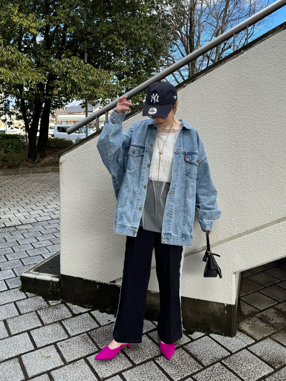 ブルー系のデニムジャケット、ブラック系のその他パンツ、ブラック系のハンドバッグを着用したレディースの冬コーディネートの4枚目の写真