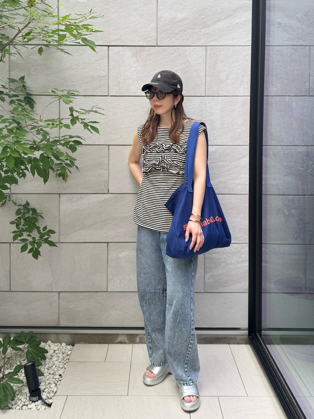 シルバー系のサンダル、ブラック系のTシャツ/カットソーを着用したレディースの夏コーディネートの2枚目の写真