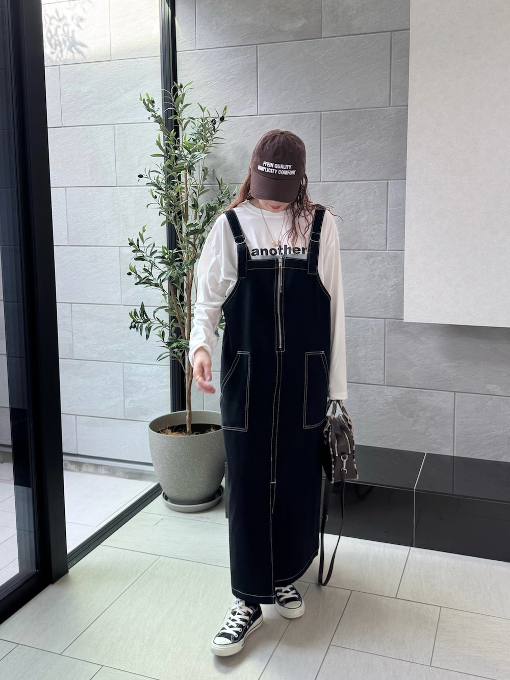 ホワイト系のTシャツ/カットソー、ブラウン系のキャップを着用したレディースの秋コーディネートの3枚目の写真