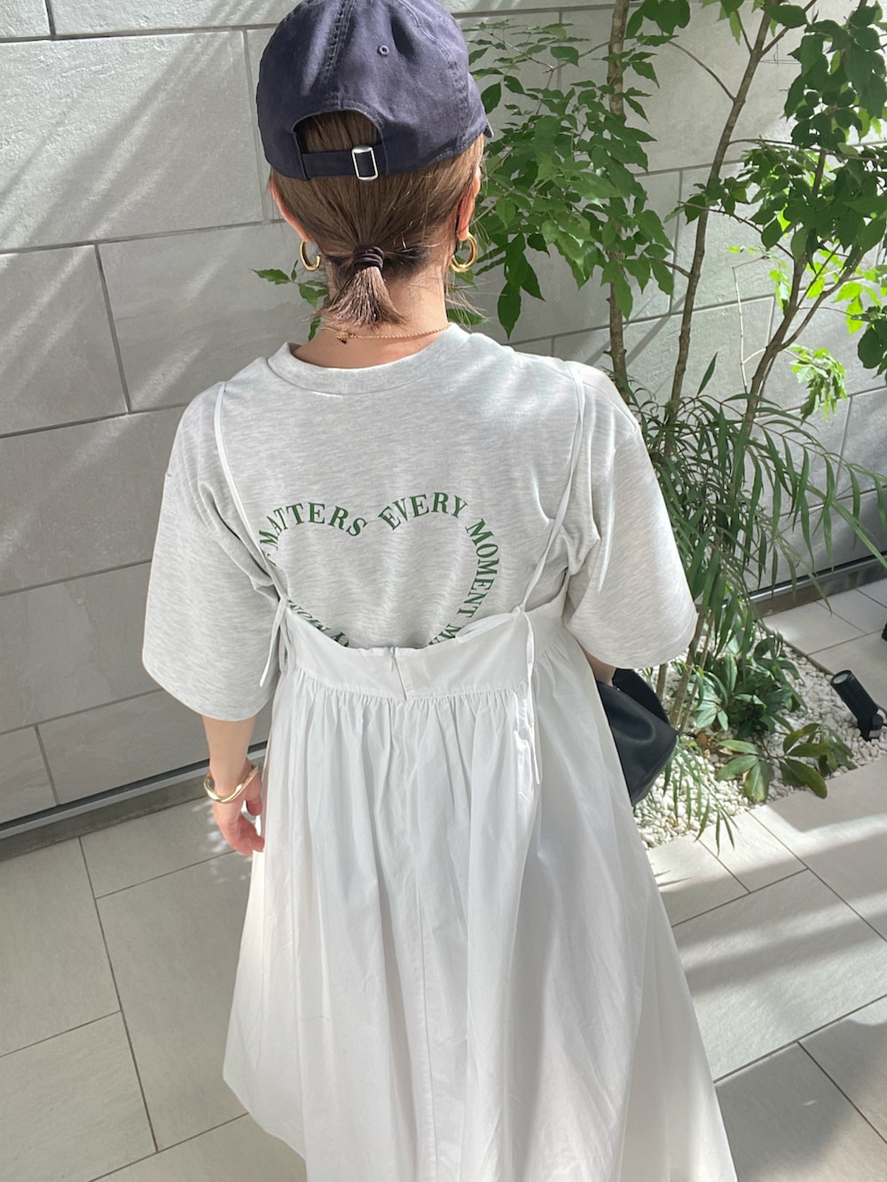 ホワイト系のワンピース、ブラック系のサンダルを着用したレディースの春コーディネートの3枚目の写真