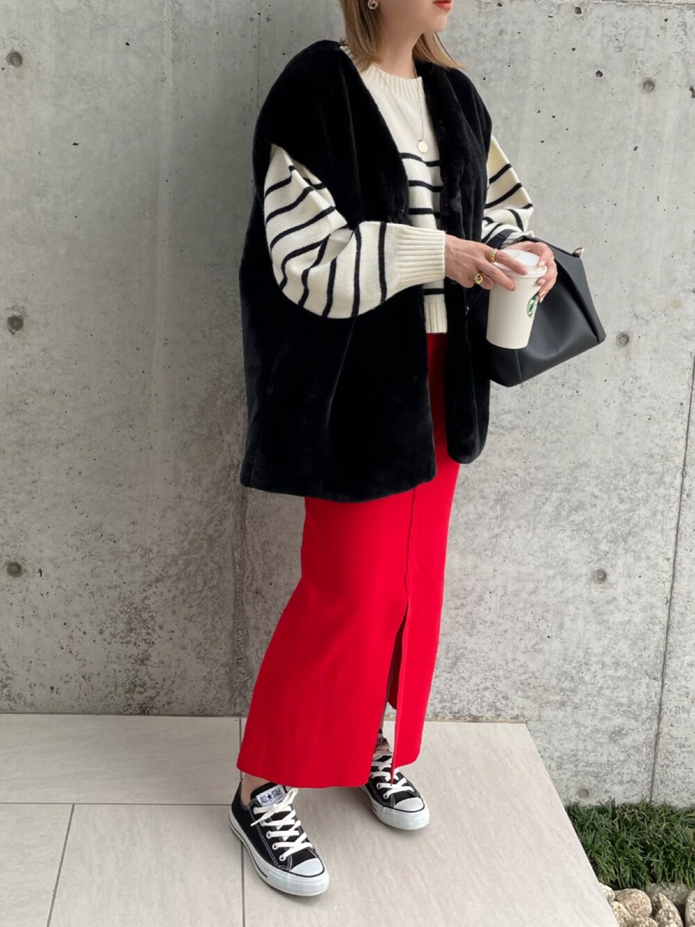 ホワイト系のニット/セーター、ブラック系のベスト、レッド系のスカートを着用したレディースの秋コーディネートの2枚目の写真
