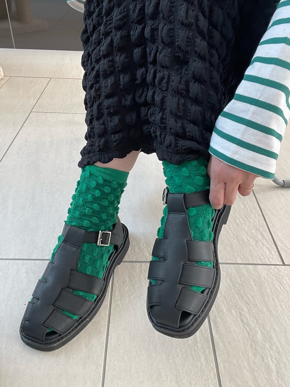 ブラック系のその他シューズ、ブラック系のスカート、ブラック系のベストを着用したレディースの春コーディネートの4枚目の写真