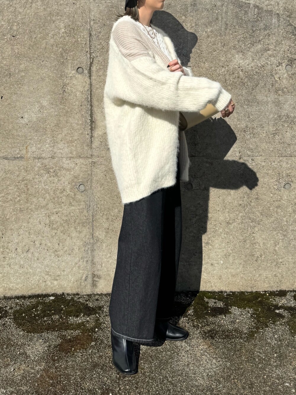 ホワイト系のカーディガン/ボレロ、ホワイト系のTシャツ/カットソー、ベージュ系のハンドバッグを着用したレディースの秋コーディネートの4枚目の写真