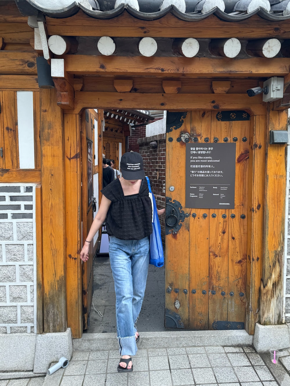 ブラック系のその他トップス、ブルー系のデニムパンツ、ブルー系のトートバッグを着用したレディースの夏コーディネートの2枚目の写真