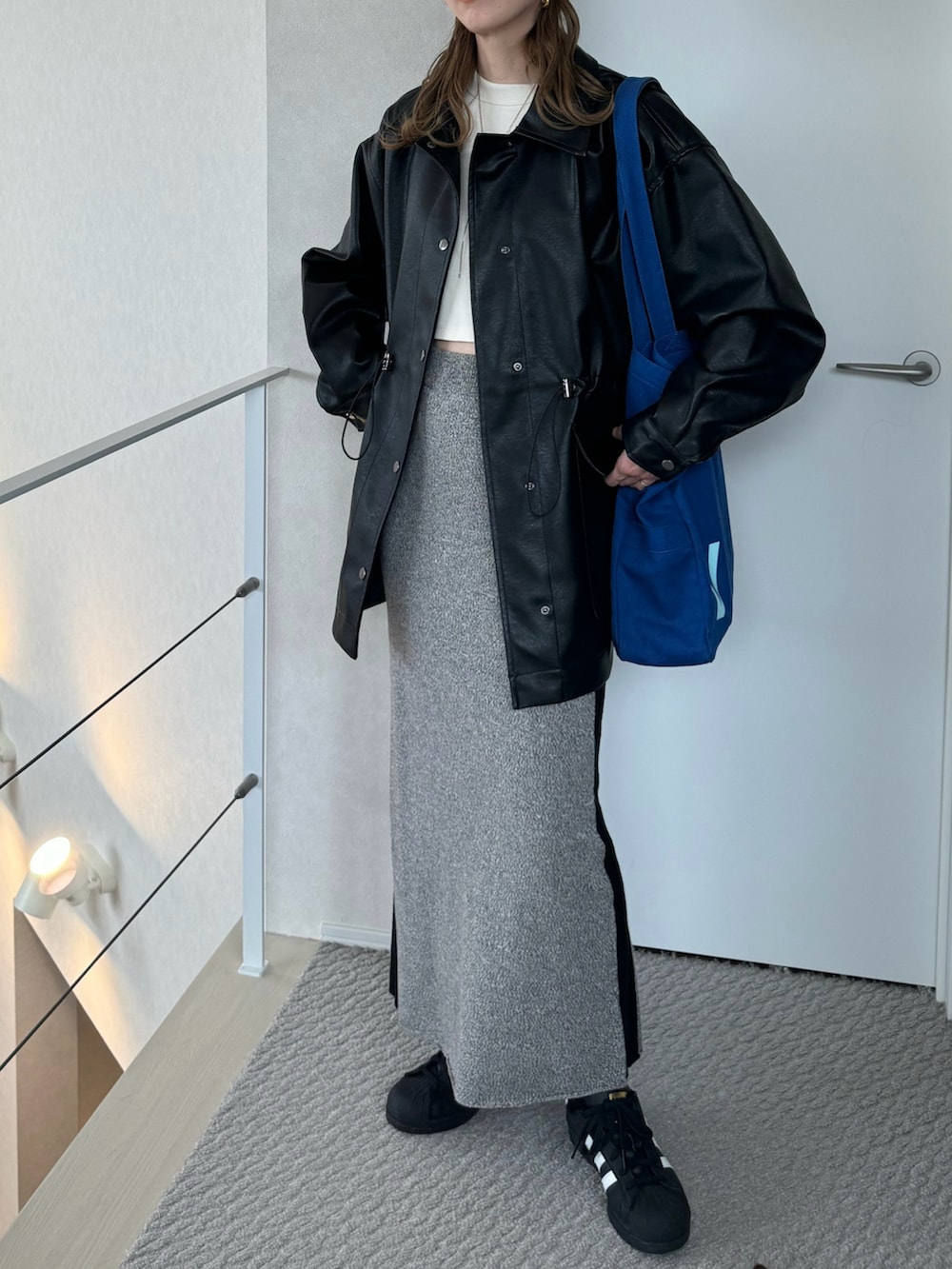 ブラック系のその他アウター、ホワイト系のTシャツ/カットソー、グレー系のスカートを着用したレディースの冬コーディネートの3枚目の写真