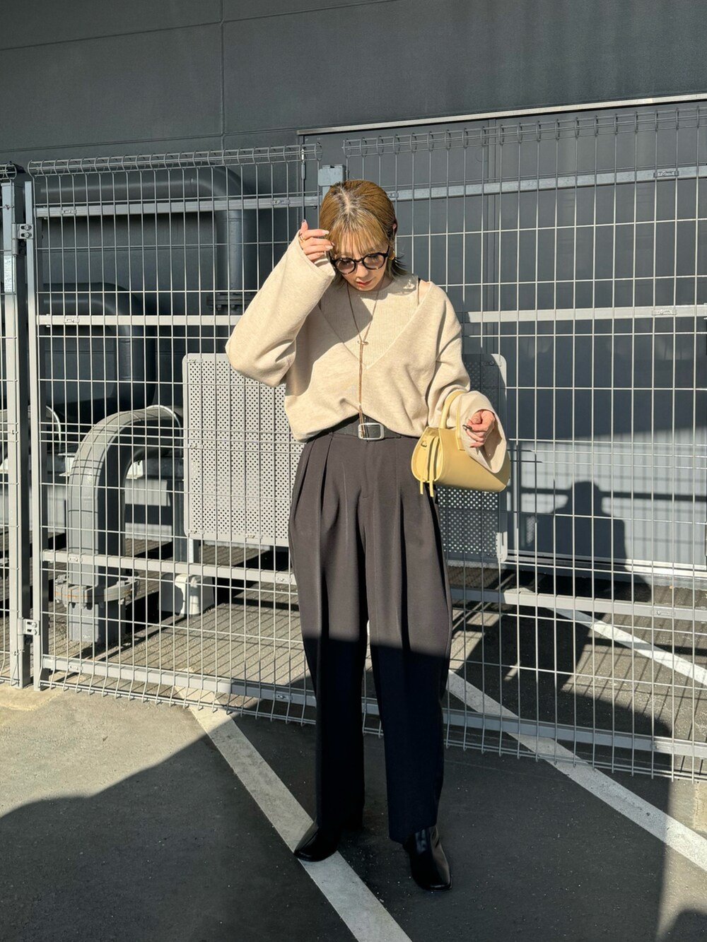 ベージュ系のニット/セーター、ブラック系のその他パンツ、ベージュ系のハンドバッグを着用したレディースの秋コーディネートの2枚目の写真