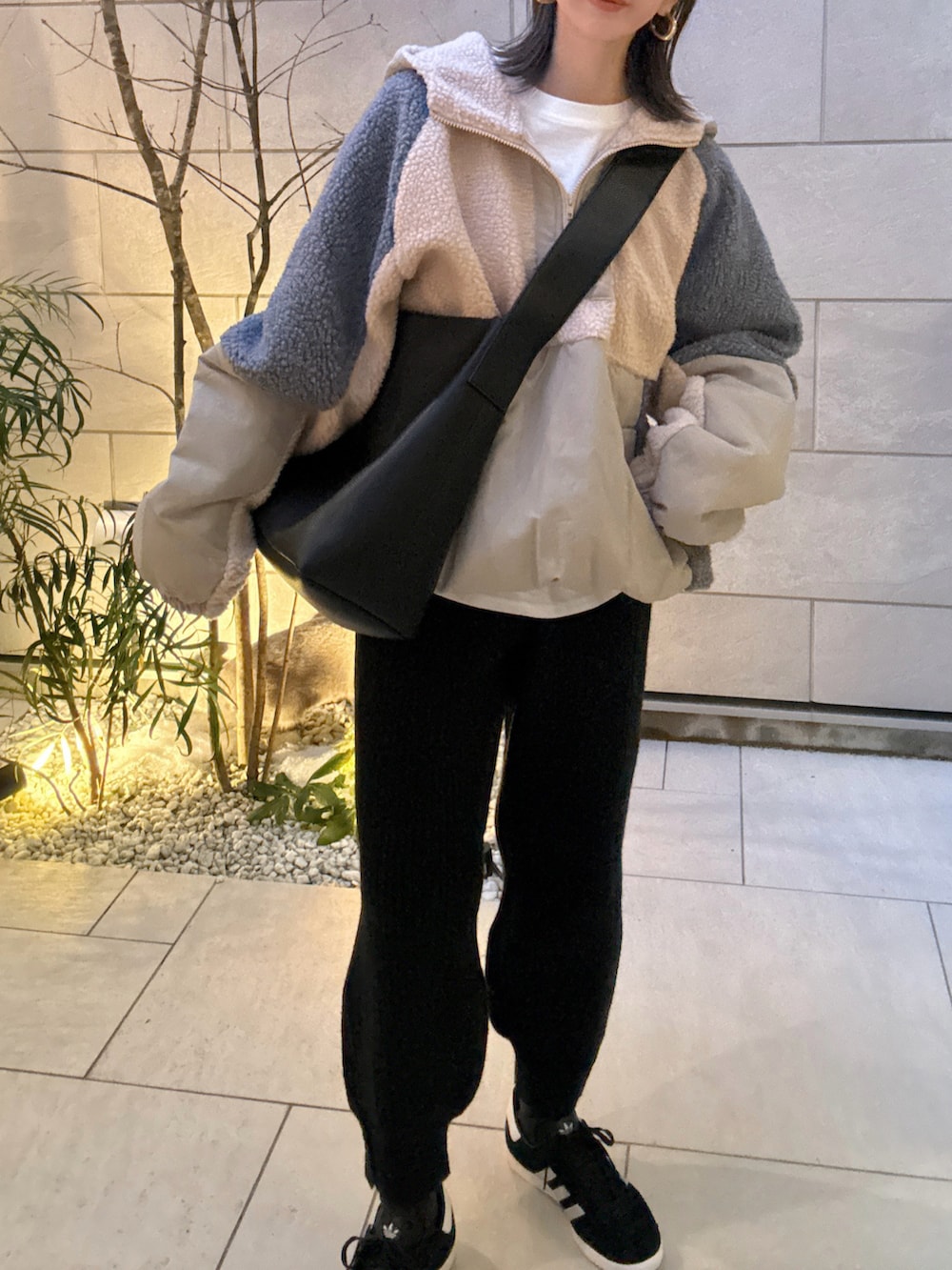 ベージュ系のブルゾン、ブラック系のショルダーバッグ、ブラック系のスニーカーを着用したレディースの冬コーディネートの3枚目の写真