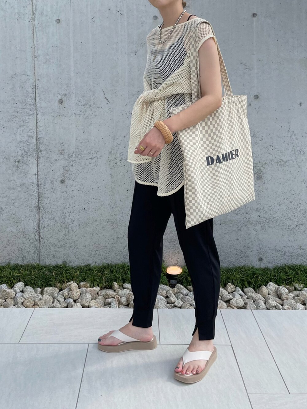 ブラック系のその他パンツ、ホワイト系のTシャツ/カットソー、ホワイト系のサンダルを着用したレディースの夏コーディネートの2枚目の写真