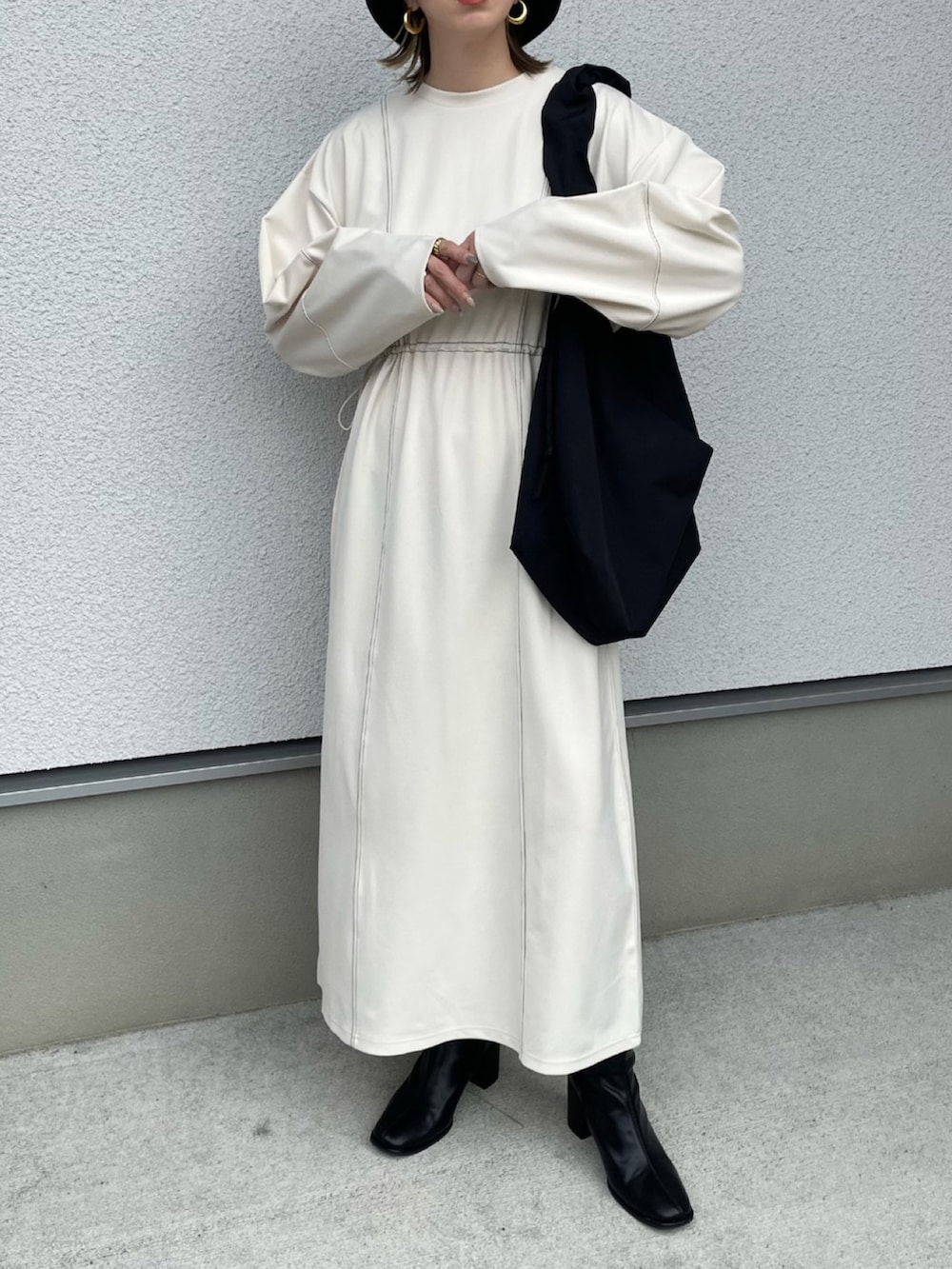 ホワイト系のワンピース、ブラック系のショルダーバッグ、ブラック系のブーツを着用したレディースの秋コーディネートの3枚目の写真