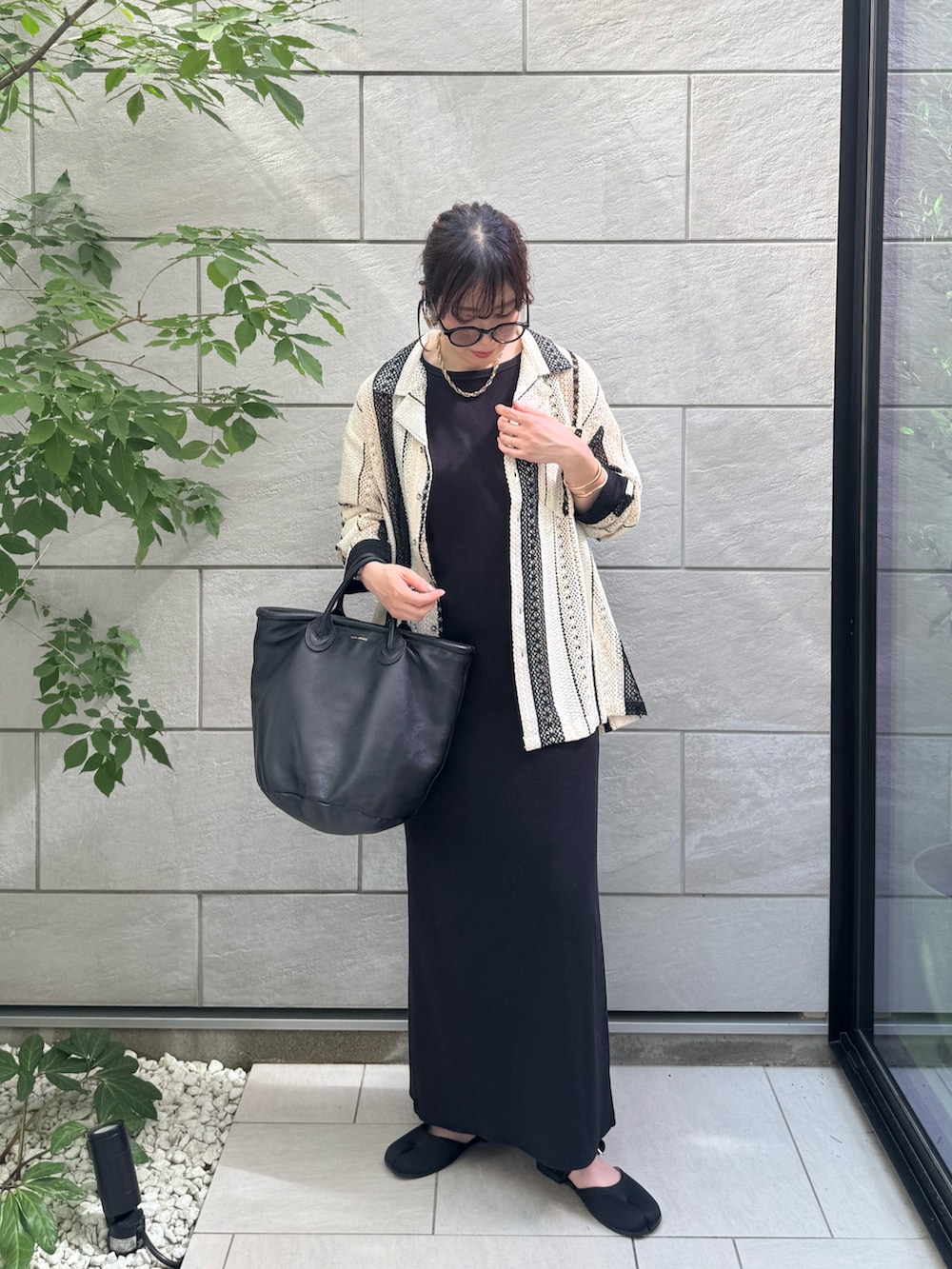 ホワイト系のシャツ/ブラウス、ブラック系のワンピース、ブラック系のサンダルを着用したレディースの夏コーディネートの2枚目の写真