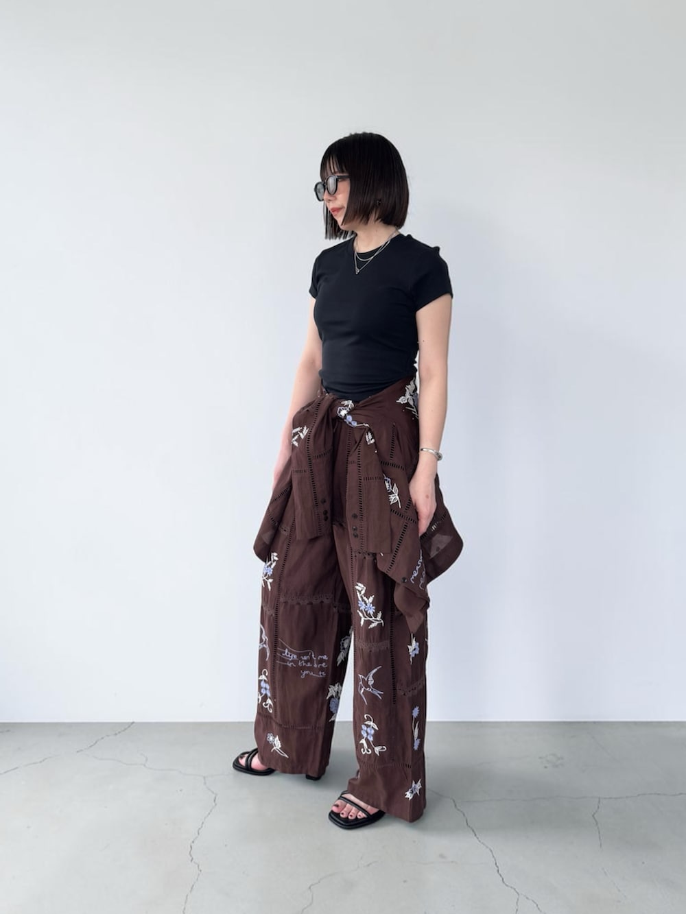 レッド系のシャツ/ブラウス、レッド系のその他パンツ、ブラック系のサンダルを着用したレディースの春コーディネートの3枚目の写真