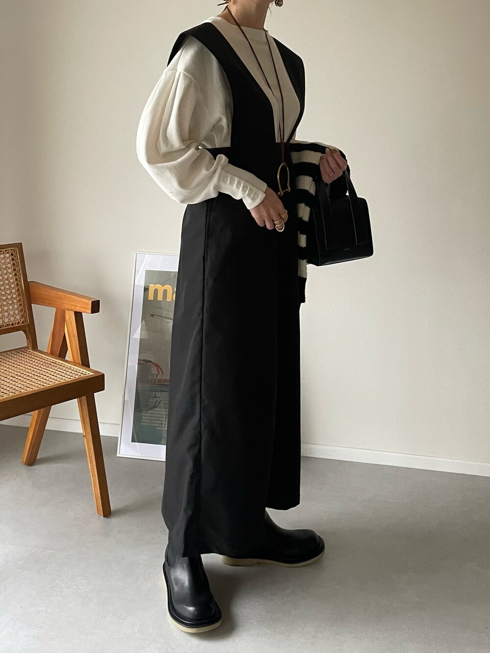 ホワイト系のTシャツ/カットソー、ブラック系のスカート、ブラック系のボストンバッグを着用したレディースの冬コーディネートの2枚目の写真