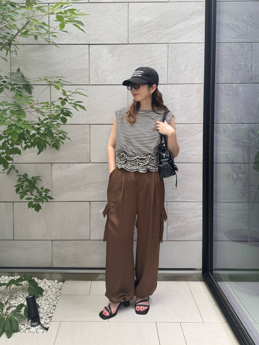 ブラウン系のその他パンツ、ブラック系のTシャツ/カットソー、ブラック系のボストンバッグを着用したレディースの夏コーディネートの3枚目の写真