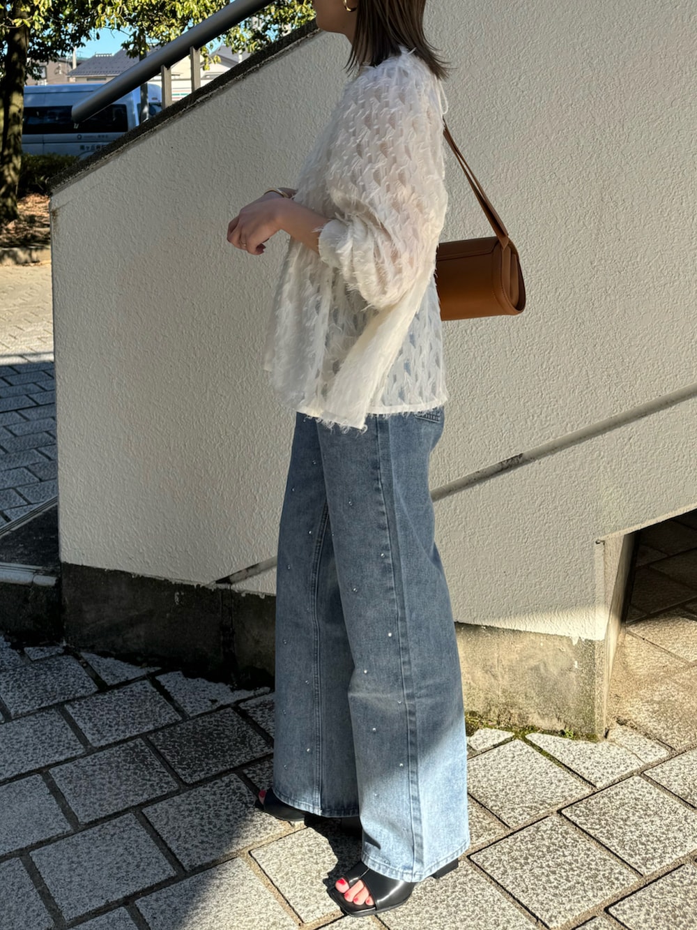 ホワイト系のシャツ/ブラウス、ブルー系のデニムパンツ、ベージュ系のショルダーバッグを着用したレディースの春コーディネートの3枚目の写真