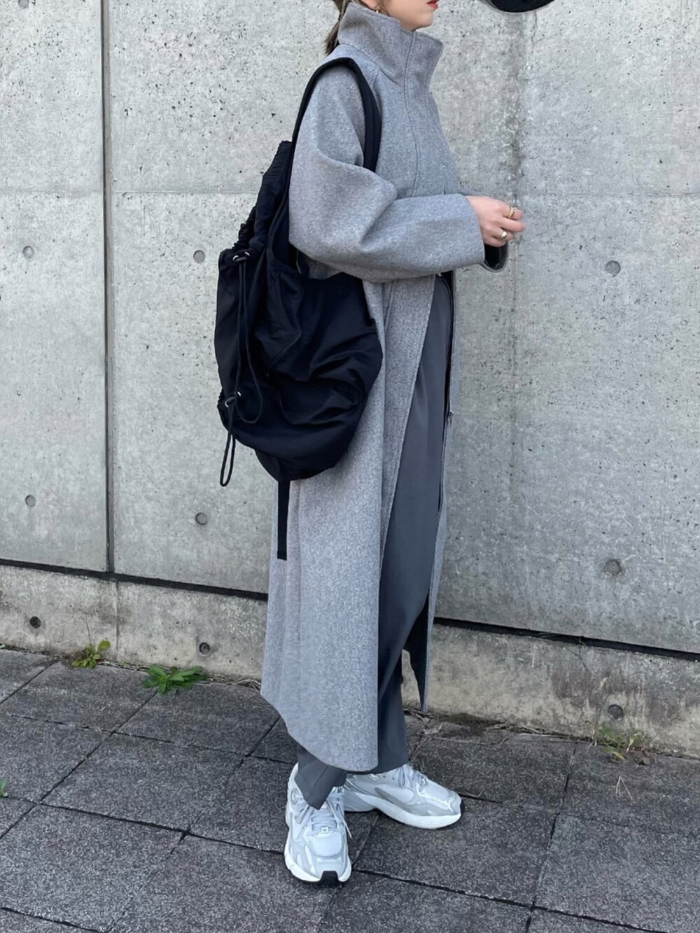 グレー系のセットアップ、グレー系のスニーカー、ブラック系のバックパック/リュックを着用したレディースの秋コーディネートの5枚目の写真