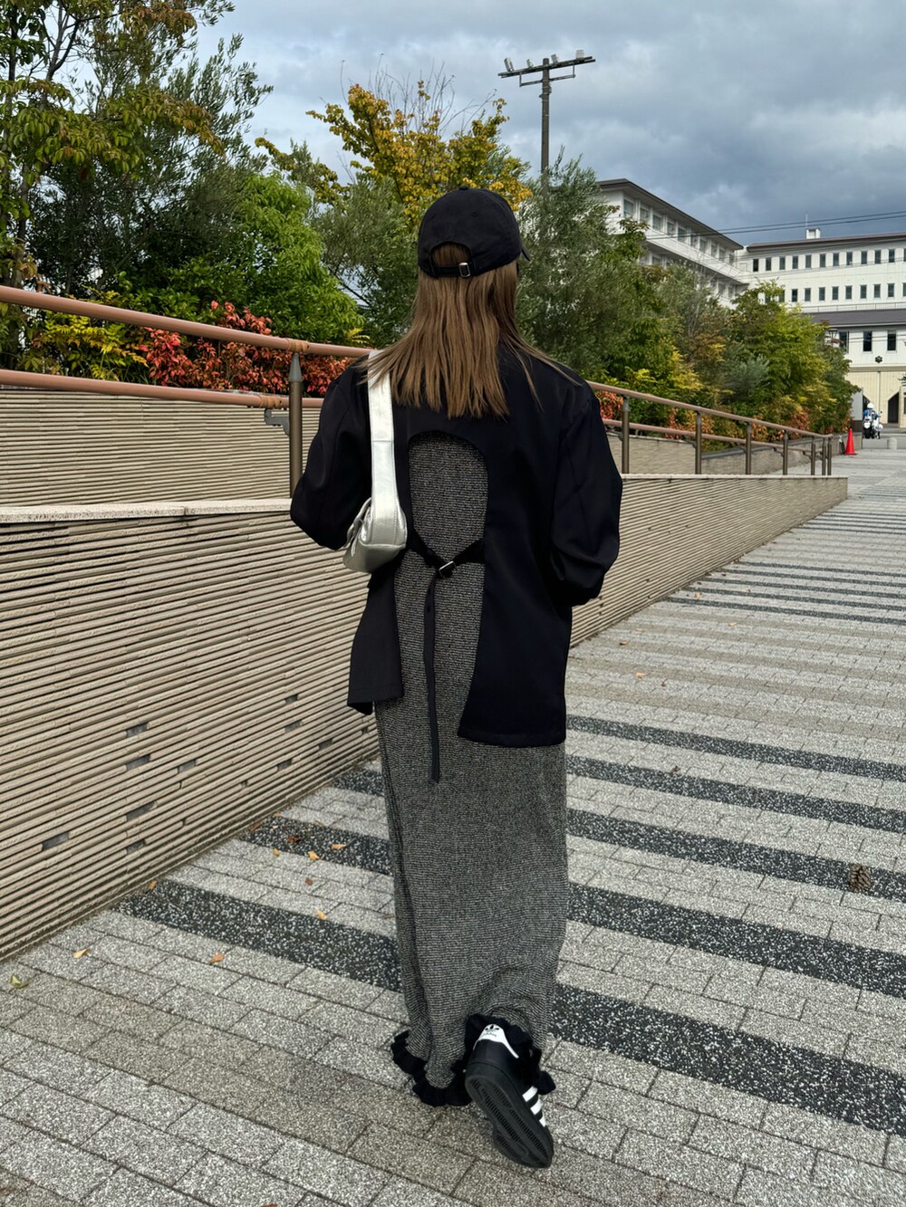 ブラック系のテーラードジャケット、ブラック系のワンピース、ブラック系のスニーカーを着用したレディースの秋コーディネートの3枚目の写真