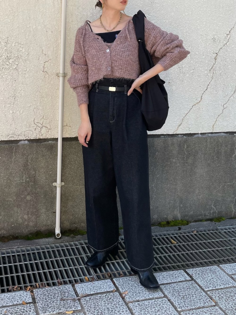 ピンク系のカーディガン/ボレロ、ブラック系のショルダーバッグ、ブラック系のデニムパンツを着用したレディースの秋コーディネートの2枚目の写真