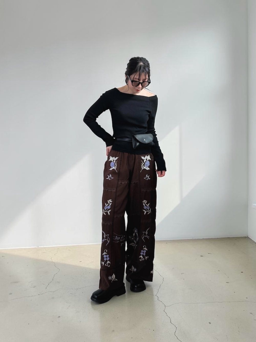 ブラック系のその他シューズ、ブラック系のボディバッグ/ウエストポーチ、ブラック系のTシャツ/カットソーを着用したレディースの春コーディネートの4枚目の写真