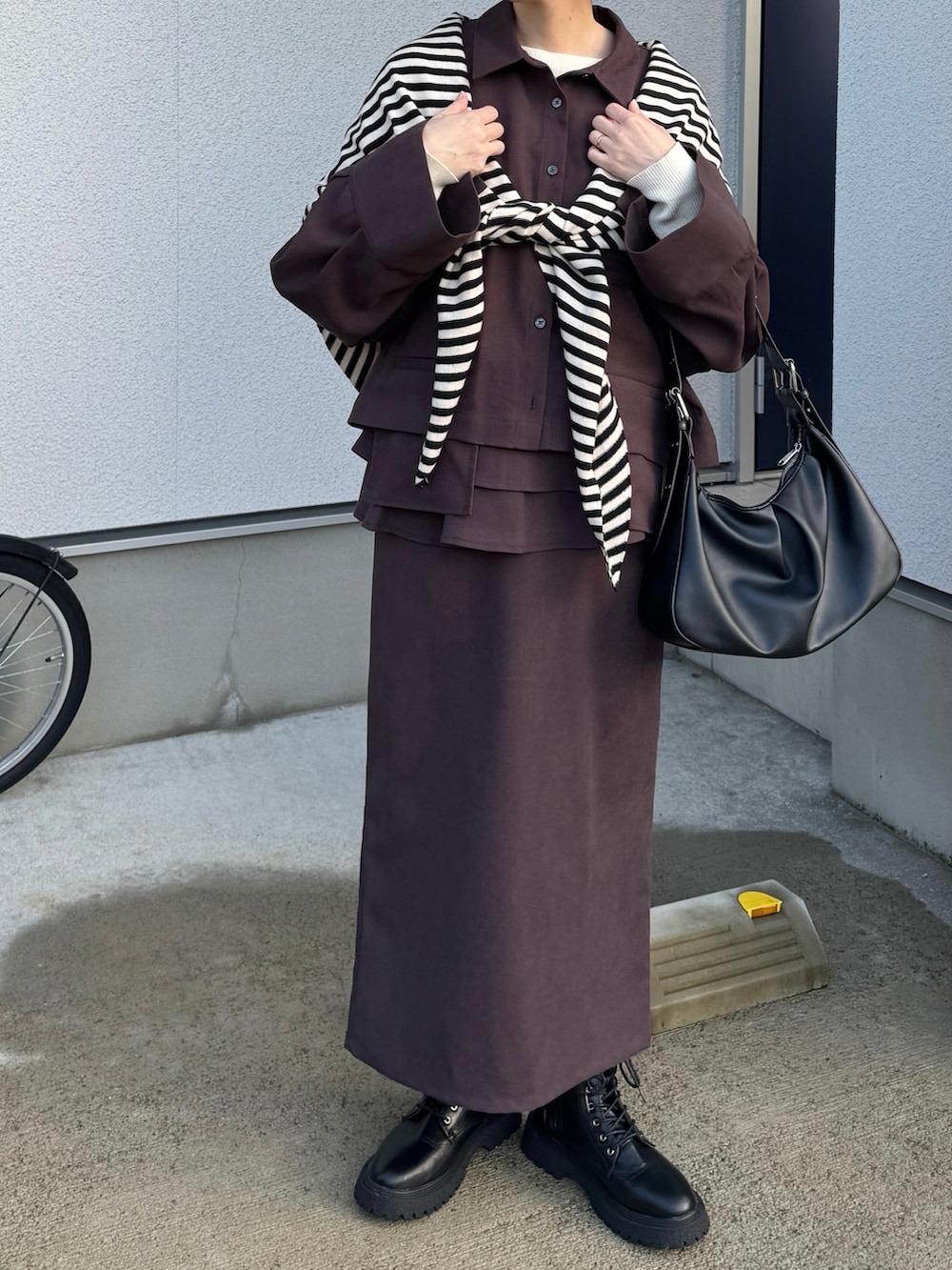 ブラウン系のシャツ/ブラウス、ブラウン系のスカート、ブラック系のハンドバッグを着用したレディースの秋コーディネートの4枚目の写真