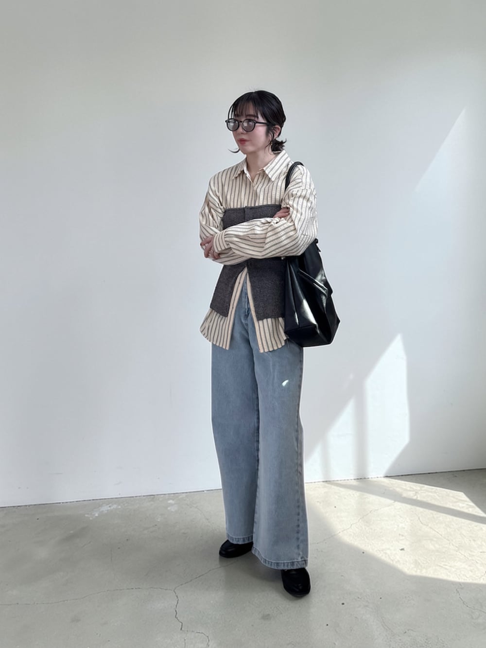 ブラック系のショルダーバッグ、イエロー系のシャツ/ブラウス、ブルー系のチューブトップを着用したレディースの春コーディネートの3枚目の写真