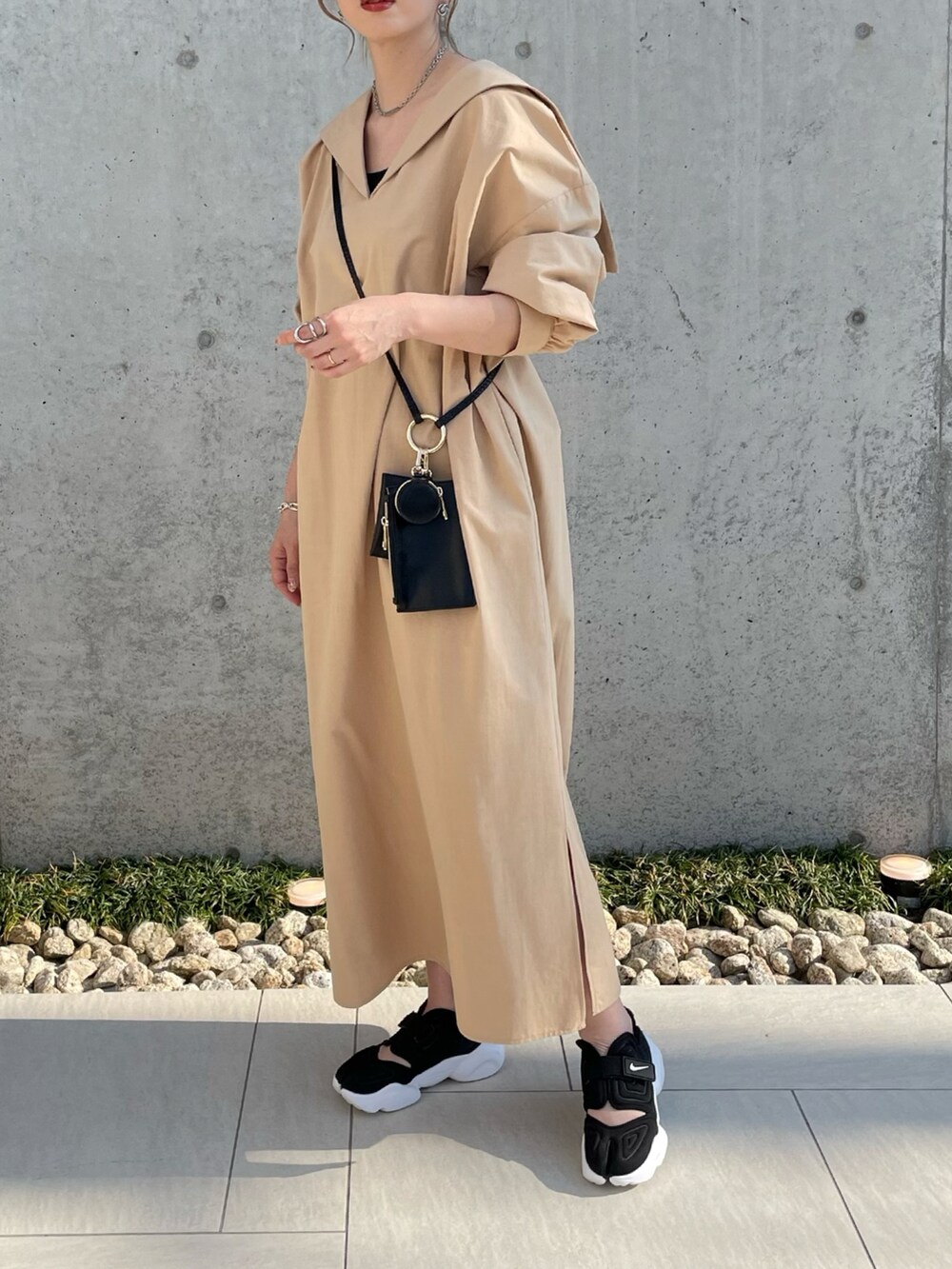 ベージュ系のシャツ/ブラウス、ブラック系のスニーカー、ブラック系のショルダーバッグを着用したレディースの春コーディネートの2枚目の写真