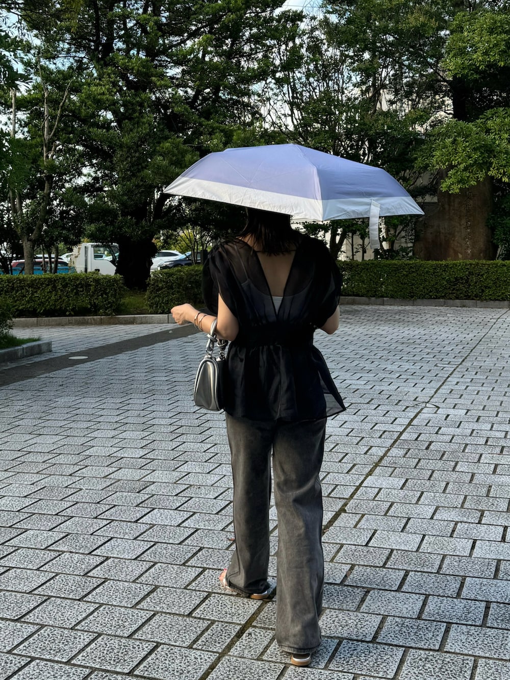 ブラック系のTシャツ/カットソー、ブラック系のデニムパンツ、シルバー系のサンダルを着用したレディースの夏コーディネートの2枚目の写真