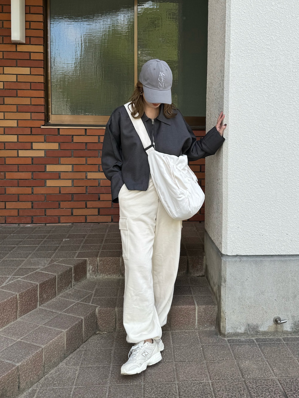 グレー系のその他アウター、ホワイト系のショルダーバッグ、グレー系のキャップを着用したレディースの秋コーディネートの4枚目の写真