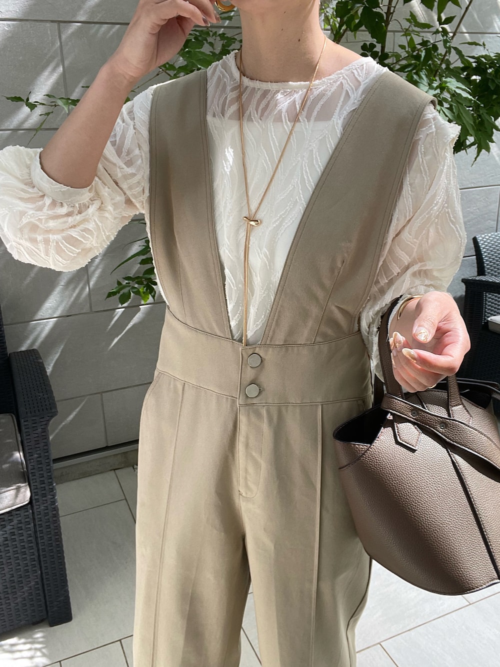 ホワイト系のシャツ/ブラウス、ベージュ系のサロペット/オーバーオール、ブラウン系のショルダーバッグを着用したレディースの春コーディネートの3枚目の写真