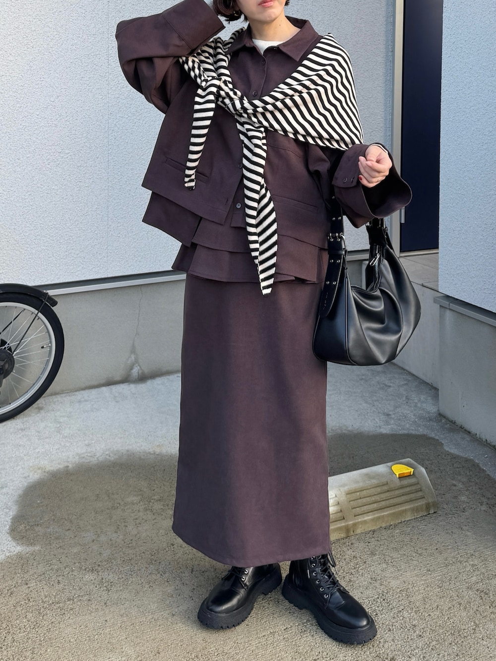 ブラウン系のシャツ/ブラウス、ブラウン系のスカート、ブラック系のハンドバッグを着用したレディースの秋コーディネートの5枚目の写真