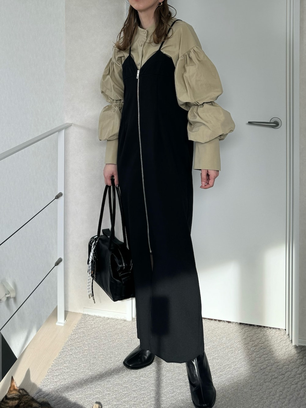 ブラック系のボストンバッグ、ベージュ系のシャツ/ブラウス、ブラック系のワンピースを着用したレディースの冬コーディネートの3枚目の写真