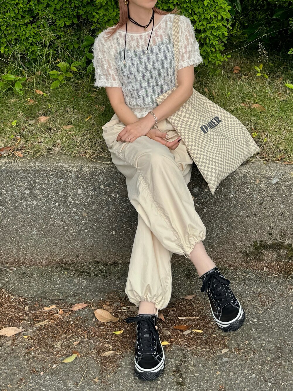 ブラック系のスニーカー、ホワイト系のTシャツ/カットソー、ベージュ系のトートバッグを着用したレディースの春コーディネートの2枚目の写真