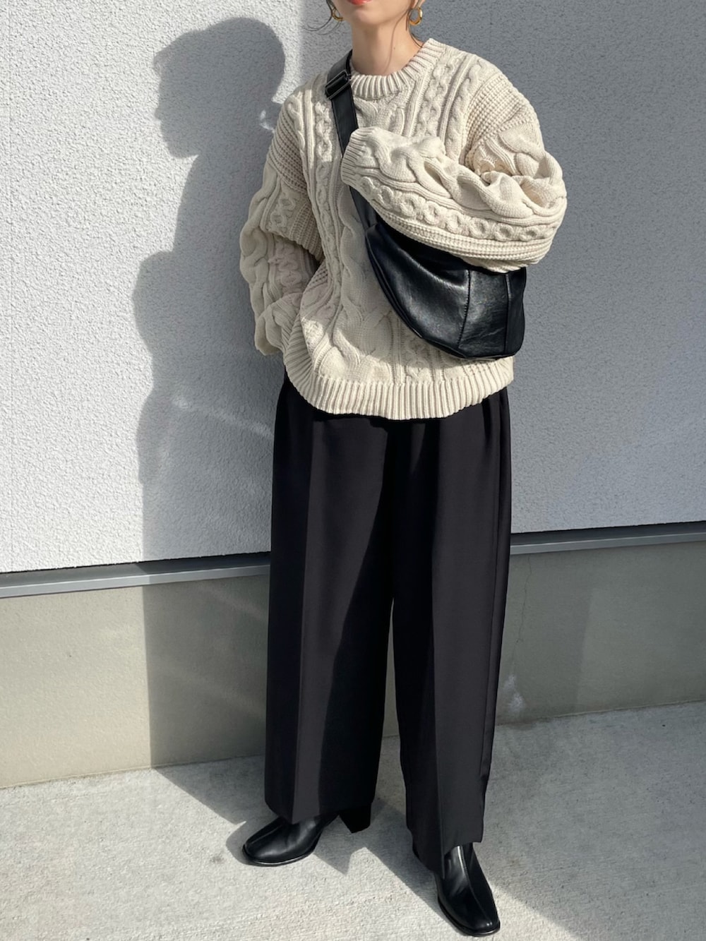 ホワイト系のニット/セーター、ブラック系のブーツ、ブラック系のその他パンツを着用したレディースの秋コーディネートの2枚目の写真