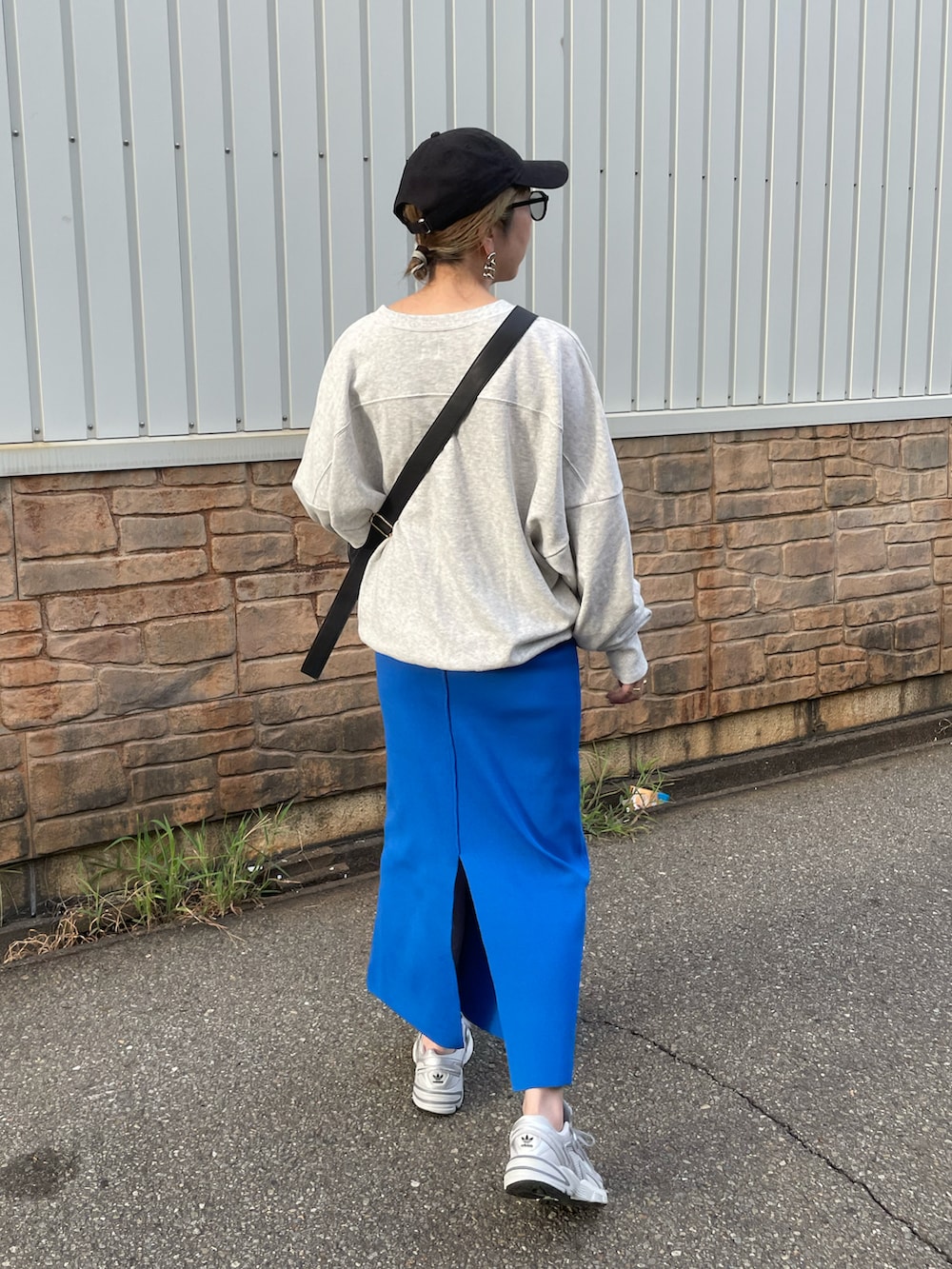 ブルー系のスカート、グレー系のスウェット、グレー系のスニーカーを着用したレディースの秋コーディネートの4枚目の写真