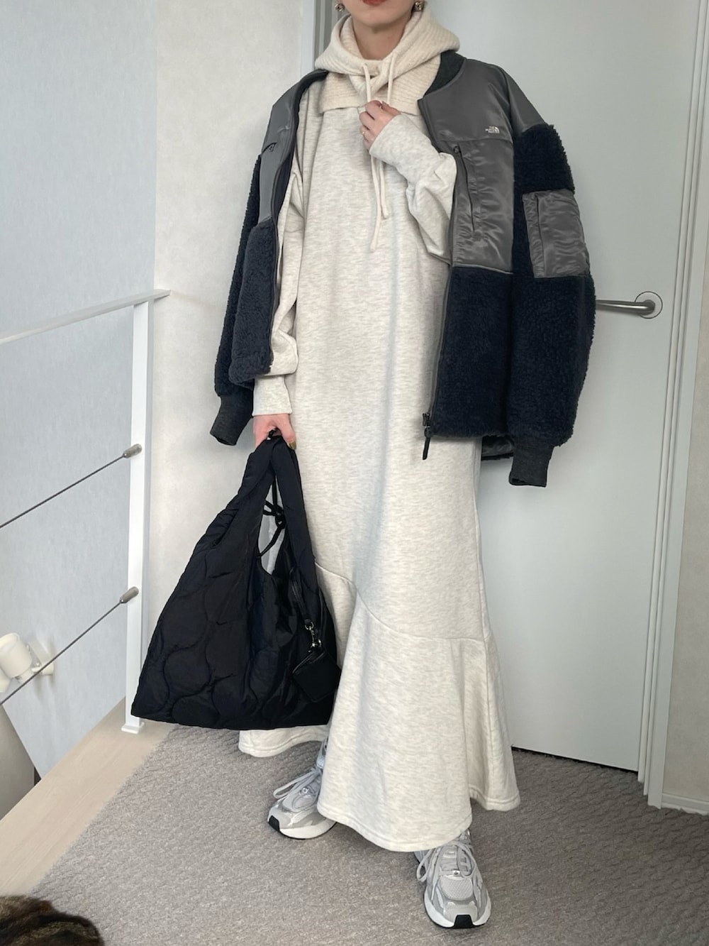 ベージュ系のワンピース、ブラック系のショルダーバッグ、グレー系のスニーカーを着用したレディースの冬コーディネートの3枚目の写真