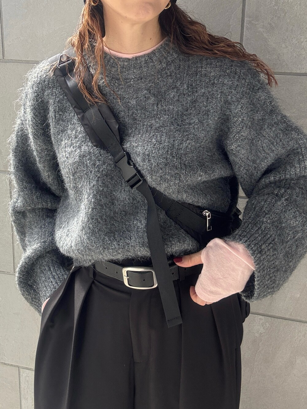 グレー系のニット/セーター、ブラック系のその他パンツ、ブラック系のボディバッグ/ウエストポーチを着用したレディースの秋コーディネートの5枚目の写真